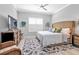 Beautiful bedroom with a ceiling fan, large bed, area rug, and a TV atop a wooden dresser at 2892 Myakka Creek Ct, Port Charlotte, FL 33953