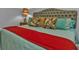 Bright bedroom features a tufted headboard and colorful decorative pillows and a lamp with a palm tree on the nightstand at 2892 Myakka Creek Ct, Port Charlotte, FL 33953