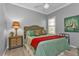 Inviting bedroom boasts a bed with tropical pillows, unique side table, and a bright window at 2892 Myakka Creek Ct, Port Charlotte, FL 33953