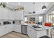 Bright white kitchen featuring stainless steel appliances, sleek countertops, and a seamless flow to the living area at 2892 Myakka Creek Ct, Port Charlotte, FL 33953