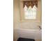 Bright bathroom featuring a large soaking tub, a window with privacy blinds, and modern fixtures at 379 Bal Harbor Blvd, Punta Gorda, FL 33950