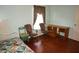 Comfortable bedroom featuring hardwood floors, two chairs, and a window for natural light at 379 Bal Harbor Blvd, Punta Gorda, FL 33950