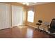 Bright bedroom featuring wood floors, three rolling chairs, and natural light from the window at 379 Bal Harbor Blvd, Punta Gorda, FL 33950