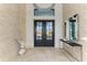 Grand foyer entrance with large double doors, stone accent wall, and stylish decor creating a welcoming ambiance at 4050 La Costa Island Ct, Punta Gorda, FL 33950