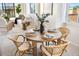 Comfortable dining area showcasing rattan chairs, a round table, and natural light at 908 Golden Beach Blvd # 201, Venice, FL 34285