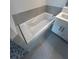 Modern bathroom featuring a white tub and vanity with gray tile flooring at 1022 S Lavina St, North Port, FL 34286