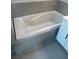 Bright bathroom featuring a white tub and gray tiled surround at 1022 S Lavina St, North Port, FL 34286