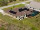 Home aerial view with solar panels and a screened-in pool in a green lawn at 1210 Nabatoff St, North Port, FL 34288