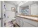 Clean bathroom featuring double sinks, granite countertops, and floral accents at 1210 Nabatoff St, North Port, FL 34288