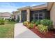 Inviting front exterior showcasing a walkway lined with colorful landscaping leading to the screened porch entrance at 1210 Nabatoff St, North Port, FL 34288