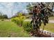 Well-manicured front yard featuring lush greenery, decorative plants, and a charming curb appeal at 1210 Nabatoff St, North Port, FL 34288