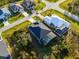 Aerial view showcasing the home with screened-in pool, lush landscaping, and nearby homes at 122 Glades Dr, Rotonda West, FL 33947