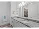 Bathroom featuring double sinks with granite countertops, light cabinets, and tiled shower at 122 Glades Dr, Rotonda West, FL 33947