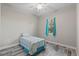 Comfortable bedroom with wood-look flooring and a bright window adorned with blue curtains at 122 Glades Dr, Rotonda West, FL 33947