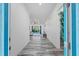 Bright hallway with stylish gray wood-look tile flooring, leading to an open living space at 122 Glades Dr, Rotonda West, FL 33947