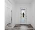 Clean hallway with gray wood-look tile flooring, leading to a decorative glass door at 122 Glades Dr, Rotonda West, FL 33947