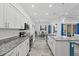 Kitchen with white cabinets, granite countertops, an island, and stainless steel appliances opens to a dining area at 122 Glades Dr, Rotonda West, FL 33947