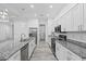 Bright kitchen features stainless steel appliances, granite countertops, white cabinets, and a central island at 122 Glades Dr, Rotonda West, FL 33947