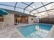 Backyard pool within a screened lanai, featuring brick pavers and a clear view of sky at 122 Glades Dr, Rotonda West, FL 33947