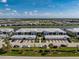 Community aerial view showcasing the beautiful townhomes, lake and landscaping at 14204 Heritage Landing Blvd # 724, Punta Gorda, FL 33955