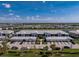 Wide aerial view of the community and condo with garages, showcasing the neighborhood's layout and surroundings near a pond at 14204 Heritage Landing Blvd # 724, Punta Gorda, FL 33955