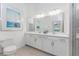 Bright bathroom with dual sinks, white cabinetry, a large mirror, and a glass-enclosed shower at 14204 Heritage Landing Blvd # 724, Punta Gorda, FL 33955