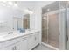 Bright bathroom with double sinks, white cabinets, and a glass-enclosed walk-in shower at 14204 Heritage Landing Blvd # 724, Punta Gorda, FL 33955