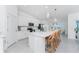 Modern white kitchen with stainless appliances, quartz countertops, pendant lights, and bar stool seating at the island at 14204 Heritage Landing Blvd # 724, Punta Gorda, FL 33955