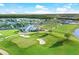 Aerial view of community with golf course, pool, and residences surrounded by greenery at 14652 Cherry Blossom Way, Punta Gorda, FL 33955