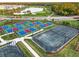 Aerial view of tennis and pickleball courts in a community with lush landscaping and a golf course at 14652 Cherry Blossom Way, Punta Gorda, FL 33955