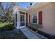 Charming screened front porch with white trim, red shutters, and neat landscaping, providing a welcoming entrance at 1498 Red Oak Ln, Port Charlotte, FL 33948