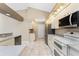 Galley kitchen with white cabinets, stainless steel appliances, and tile floors at 15090 Buswell Ave, Port Charlotte, FL 33953