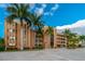 Multi-story condo building featuring a courtyard, covered parking and lush landscaping with mature palm trees at 1601 Park Beach Cir # 112/2, Punta Gorda, FL 33950