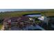 Aerial view of a red and yellow three-story apartment building with a white two-story house on a waterfront property at 17495 Boca Vista Rd # 6, Punta Gorda, FL 33955