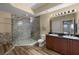 Bathroom featuring double sinks, a large walk-in shower, tile surround and wood-style floors at 17495 Boca Vista Rd # 6, Punta Gorda, FL 33955
