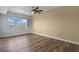 Bedroom with a ceiling fan and natural light from a window with light blue walls and wood laminate flooring at 17495 Boca Vista Rd # 6, Punta Gorda, FL 33955