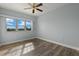 Bright bedroom featuring wood-look floors, a ceiling fan, and a large window with a scenic view at 17495 Boca Vista Rd # 6, Punta Gorda, FL 33955