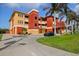 View of the multi-level condominium with stucco siding, beautiful landscaping and convenient parking at 17495 Boca Vista Rd # 6, Punta Gorda, FL 33955