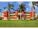 Multi-level condominium building featuring vibrant colors, well-manicured lawns, and mature palm trees at 17495 Boca Vista Rd # 6, Punta Gorda, FL 33955
