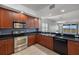 Cherry-toned kitchen with stainless steel appliances and black countertops that opens to the dining and living areas at 17495 Boca Vista Rd # 6, Punta Gorda, FL 33955