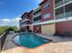 Community pool and sun deck near colorful buildings under a blue sky with a few clouds at 17495 Boca Vista Rd # 6, Punta Gorda, FL 33955