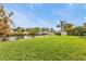 A spacious grassy lawn extends to a canal with a private dock, perfect for waterfront enjoyment at 18536 Alphonse Cir, Port Charlotte, FL 33948