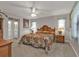 Spacious main bedroom with a large bed, ceiling fan, and natural light. Also features ensuite bathroom at 18536 Alphonse Cir, Port Charlotte, FL 33948