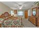 Spacious main bedroom with a large bed, ceiling fan, and natural light and decor at 18536 Alphonse Cir, Port Charlotte, FL 33948