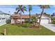 Charming home with a well-manicured lawn and tropical landscaping, creating curb appeal at 18536 Alphonse Cir, Port Charlotte, FL 33948