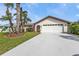 Charming single-story home with an attached two-car garage, well-maintained landscaping, and a long driveway at 18536 Alphonse Cir, Port Charlotte, FL 33948