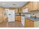 Functional kitchen with white appliances, granite counters, tile floor and hardwood cabinets at 18536 Alphonse Cir, Port Charlotte, FL 33948