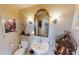Classic half-bathroom with pedestal sink, decorative mirror and patterned floral decor at 19170 Aviation Ct, Port Charlotte, FL 33948