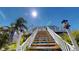 Home features a white wooden staircase leading up to a wraparound deck at 19170 Aviation Ct, Port Charlotte, FL 33948