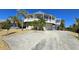 This two-story circular home features a garage, balconies, and a wide driveway with parking at 19170 Aviation Ct, Port Charlotte, FL 33948